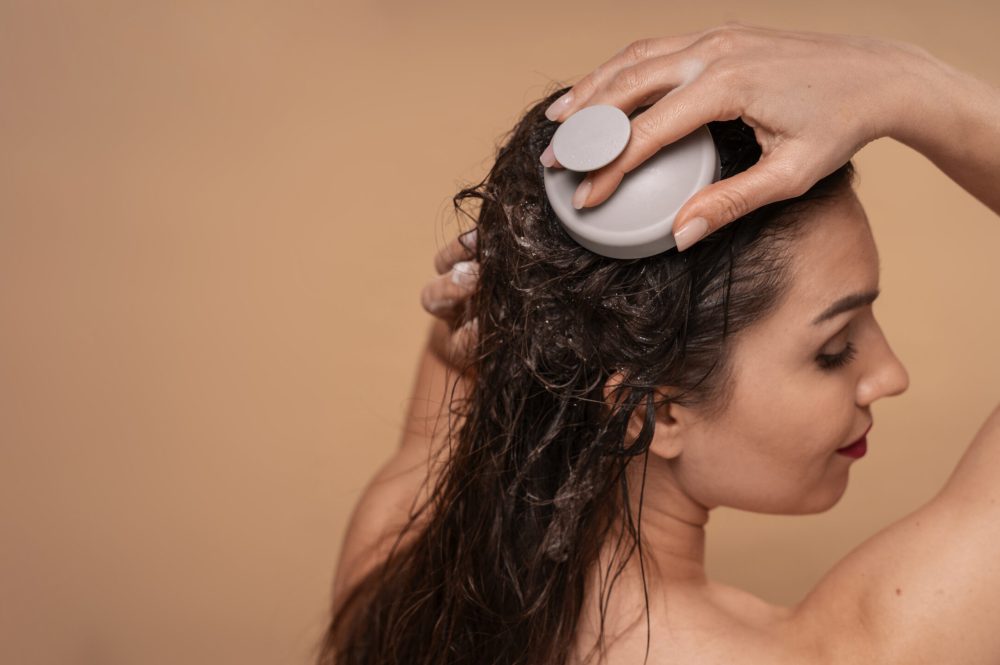 medium-shot-woman-giving-herself-scalp-massage
